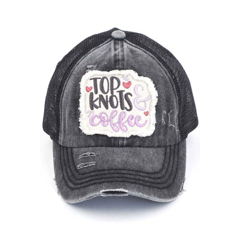 Black C.C DISTRESSED TOP KNOTS AND COFFEE PATCH PONYCAP is an essential accessory for coffee lovers. Made with distressed fabric and a stylish top knot, it also features an embroidered coffee patch. Stay fashionable while showing off your love for coffee.