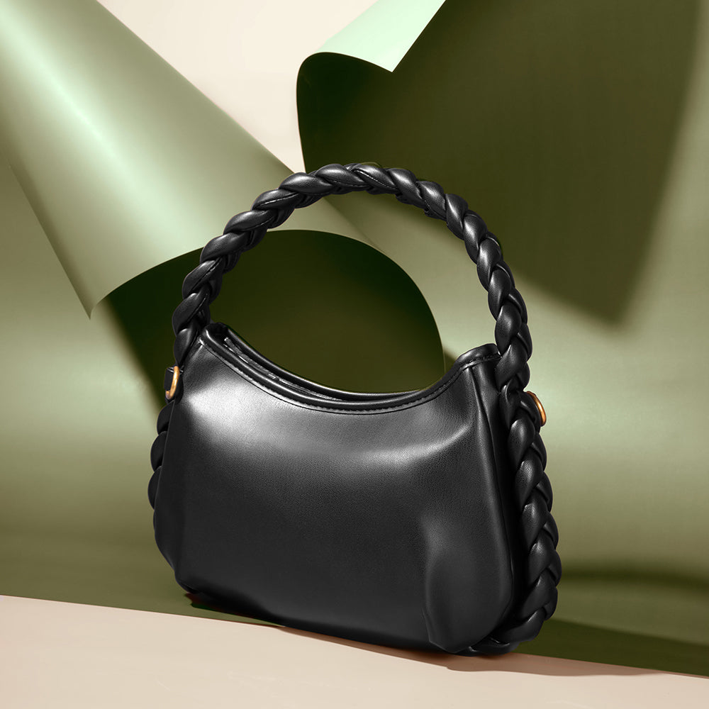 A still image of a small black recycled vegan leather shoulder bag with a braided handle.