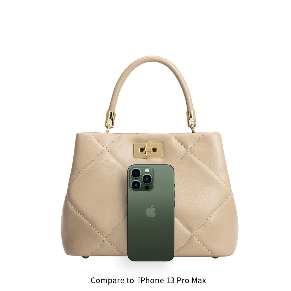 A nude crossbody handbag with an Iphone for space comparison. 