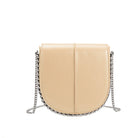 A nude vegan leather crossbody handbag with silver handle.