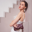 A model wearing a small quilted vegan leather shoulder bag with gold M hardware. 