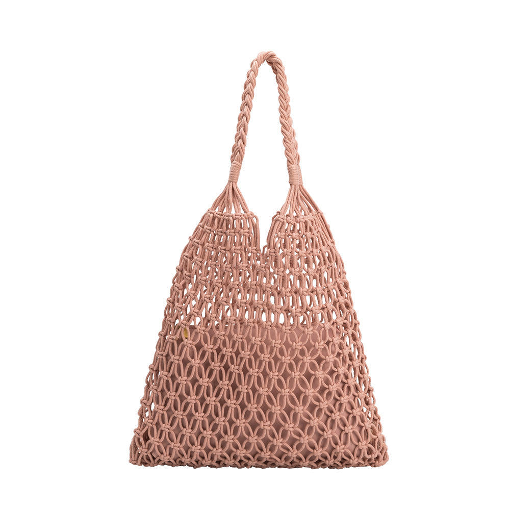 A medium blush crochet shoulder bag with a braided handle. 