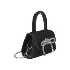 A mini black velvet top handle bag with a silver encrusted bow.