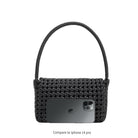 An iphone 14 pro size comparison image for a small crocheted recycled vegan leather shoulder bag.