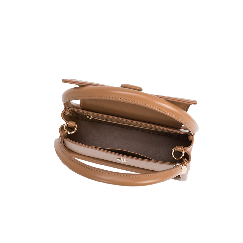 A taupe structured vegan leather crossbody bag with double handles. 