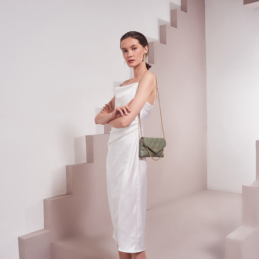 Model Wearing Melie Bianco Luxury Vegan Leather Gigi Clutch Bag in Sage with gold chain
